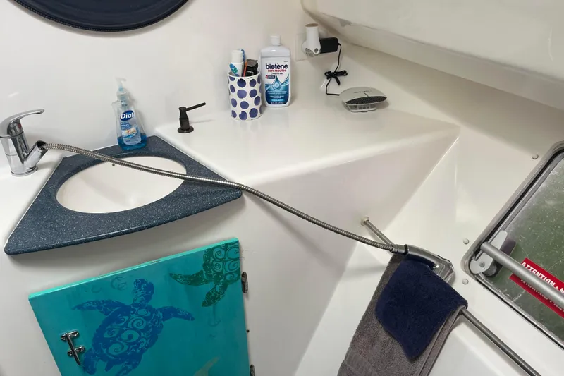 Sea Glass Yacht Photos Pics Bathroom sink area on 2000 Fountaine Pajot Belize 43 catamaran with toiletries and turtle-themed cabinet.