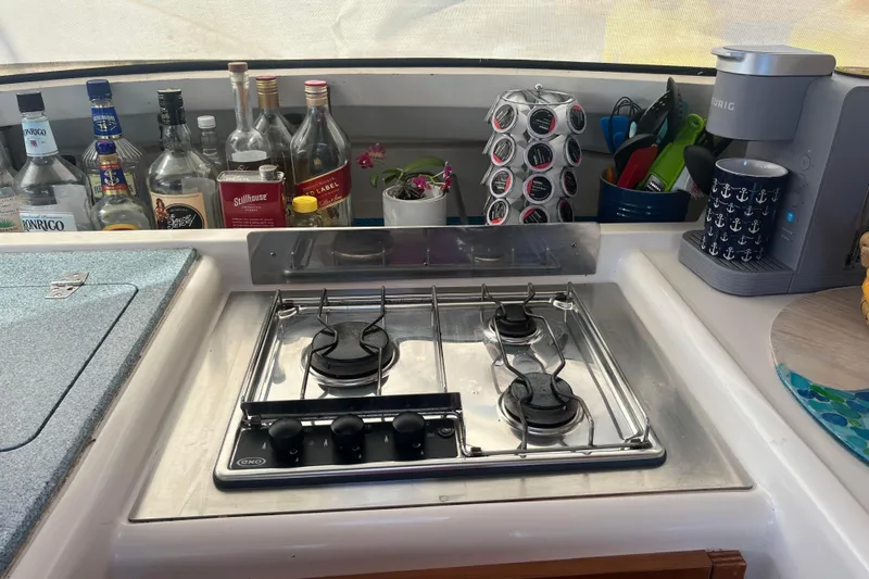 Sea Glass Yacht Photos Pics Galley kitchen in 2000 Fountaine Pajot Belize 43 with stove, coffee maker, and bottles.