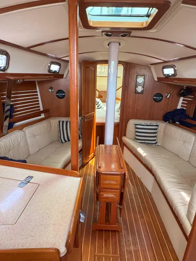 Side Aye Yacht Photos Pics Interior of a 2009 Tartan 3400 sailboat with wood finish and beige seating.