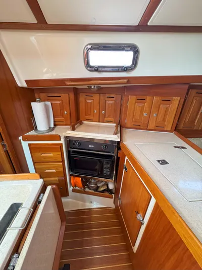 Side Aye Yacht Photos Pics 2009 Tartan 3400 yacht kitchen with wooden cabinets and modern appliances.