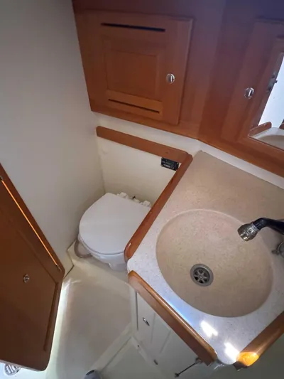 Side Aye Yacht Photos Pics Compact bathroom in 2009 Tartan 3400 yacht with sink, toilet, and wooden cabinetry.