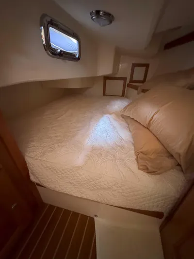 Side Aye Yacht Photos Pics Cozy cabin interior of 2009 Tartan 3400 yacht with bed and porthole window.