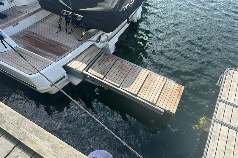 Three Bears Yacht Photos Pics Fairline Targa 58 yacht with extended wooden gangway, docked on calm water.