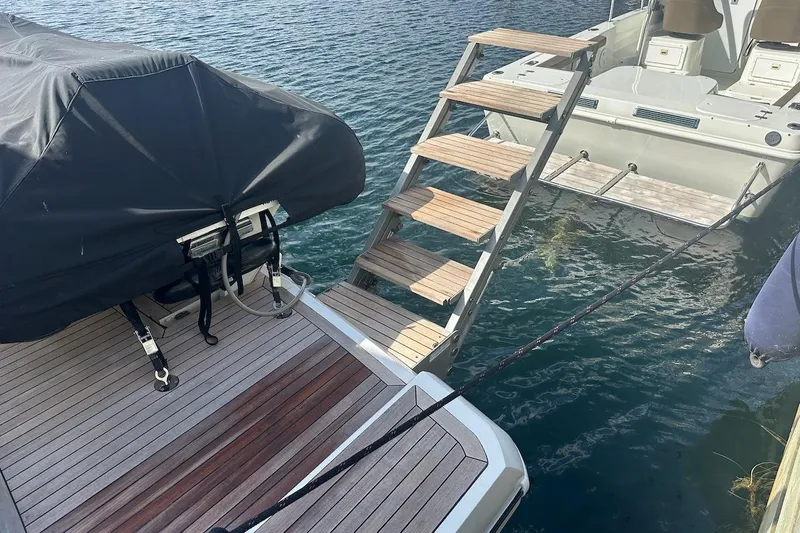 Three Bears Yacht Photos Pics Fairline Targa 58 yacht, 2012 model, with covered equipment and wooden steps over water.