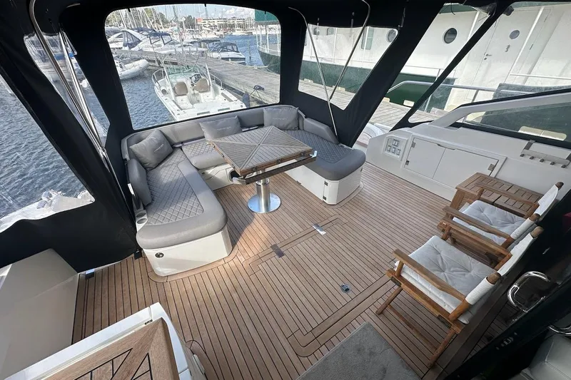 Three Bears Yacht Photos Pics Luxurious 2012 Fairline Targa 58 yacht deck with seating and table, docked at marina.