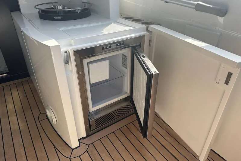 Three Bears Yacht Photos Pics Open mini fridge on 2012 Fairline Targa 58 yacht with wooden deck flooring.