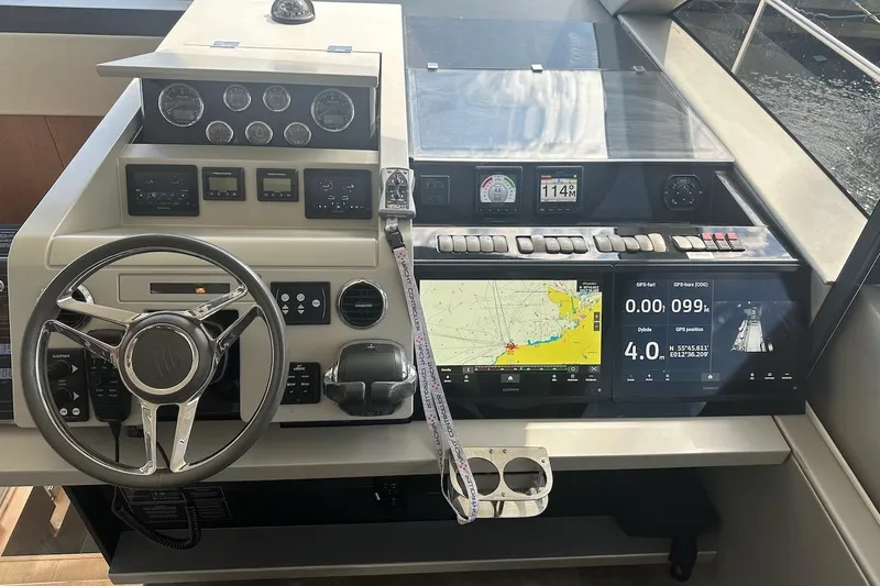 Three Bears Yacht Photos Pics Control panel of a 2012 Fairline Targa 58 yacht with navigation displays and steering wheel.