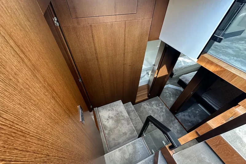 Three Bears Yacht Photos Pics Interior staircase of 2012 Fairline Targa 58 yacht with wooden paneling and carpeted steps.