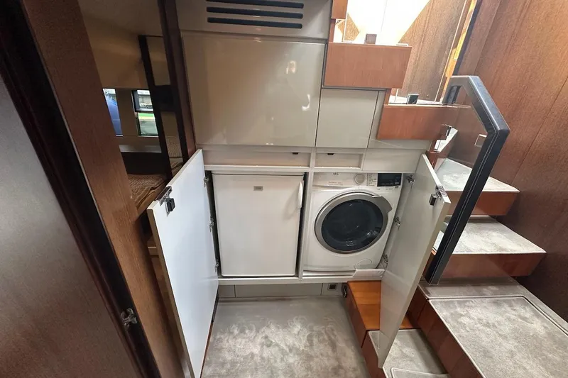 Three Bears Yacht Photos Pics Laundry area on 2012 Fairline Targa 58 yacht with washer and storage cabinets.