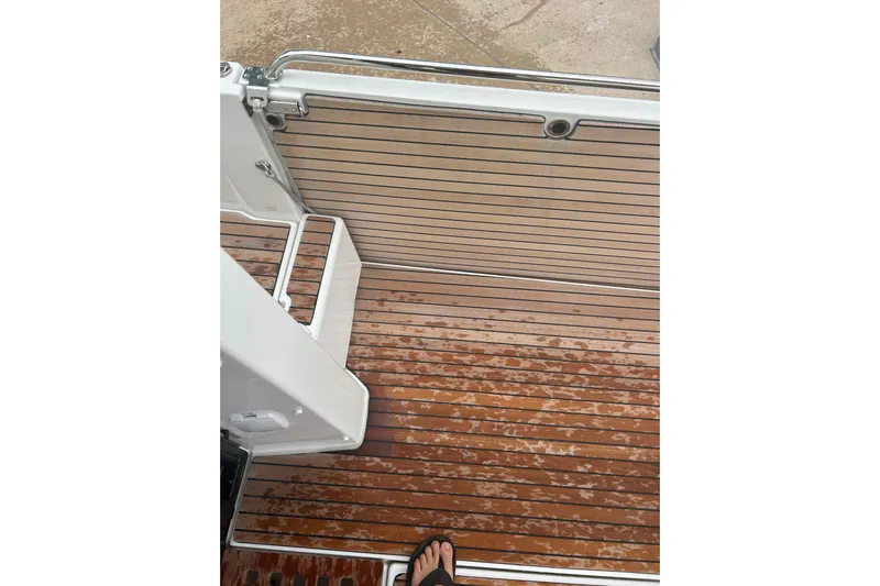  Yacht Photos Pics 2025 Beneteau Antares 11 Coupe deck with wet wooden flooring and metal railing.