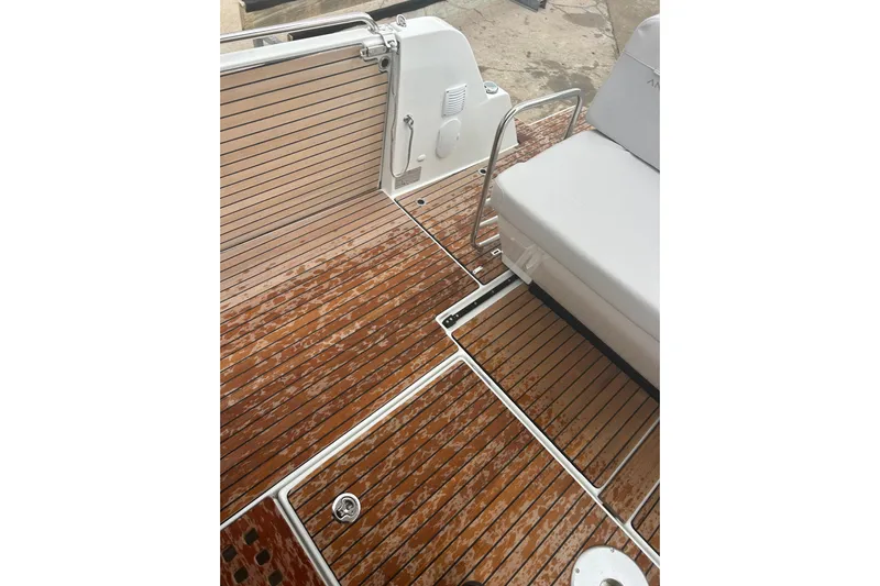  Yacht Photos Pics 2025 Beneteau Antares 11 Coupe deck with teak flooring and seating area.