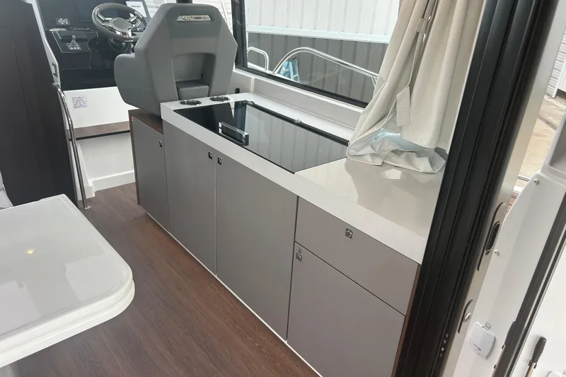  Yacht Photos Pics Interior of 2025 Beneteau Antares 11 Coupe with modern kitchen and helm station.
