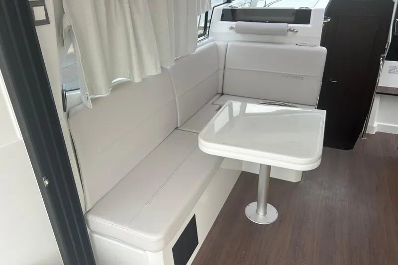  Yacht Photos Pics Interior of 2025 Beneteau Antares 11 Coupe with white seating and table.
