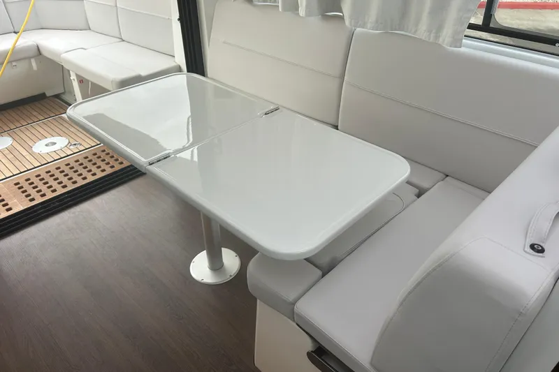  Yacht Photos Pics Interior of 2025 Beneteau Antares 11 Coupe with sleek white seating and table.
