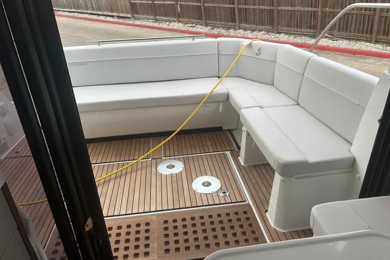  Yacht Photos Pics 2025 Beneteau Antares 11 Coupe interior with white seating and wooden flooring.