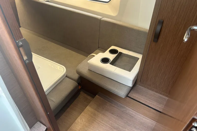  Yacht Photos Pics Interior of 2025 Beneteau Antares 11 Coupe, featuring cozy seating and wooden finishes.