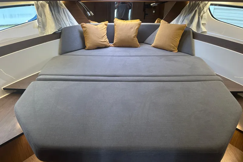  Yacht Photos Pics 2025 Beneteau Antares 11 Coupe interior with gray seating and yellow cushions.