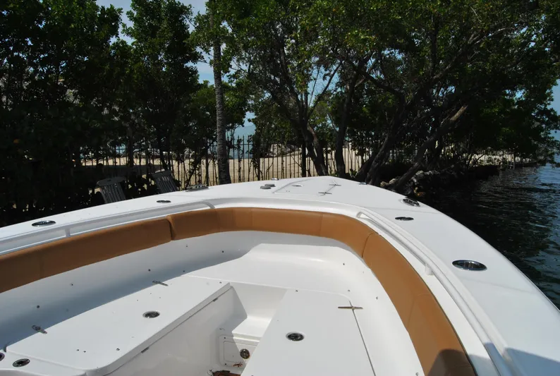  Yacht Photos Pics 2020 Sea Hunt Gamefish 30 boat with tan seating, docked near lush trees.