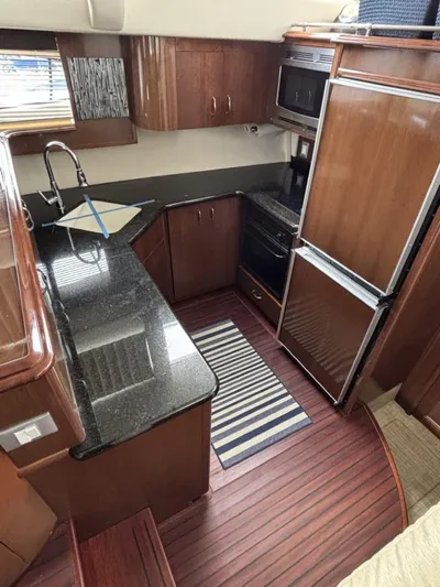 Odyssea II Yacht Photos Pics Luxurious kitchen interior of 2009 Carver 46 Motor Yacht with wood cabinetry and granite countertops.