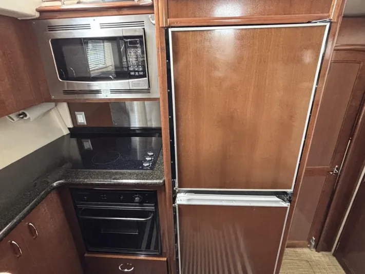 Odyssea II Yacht Photos Pics Kitchen area of 2009 Carver 46 Motor Yacht with microwave, stove, and refrigerator.