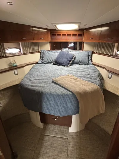 Odyssea II Yacht Photos Pics Luxurious bedroom in 2009 Carver 46 Motor Yacht with cozy bedding and elegant wood cabinetry.