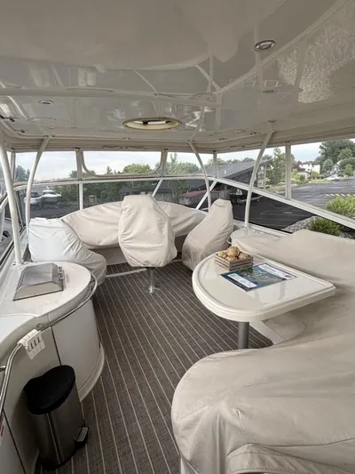 Odyssea II Yacht Photos Pics 2009 Carver 46 Motor Yacht interior with covered seating and table, featuring panoramic windows.