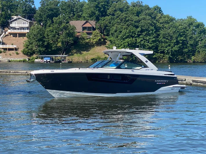  Yacht Photos Pics 2022 Monterey 378SS boat on a serene lake with lush green surroundings.
