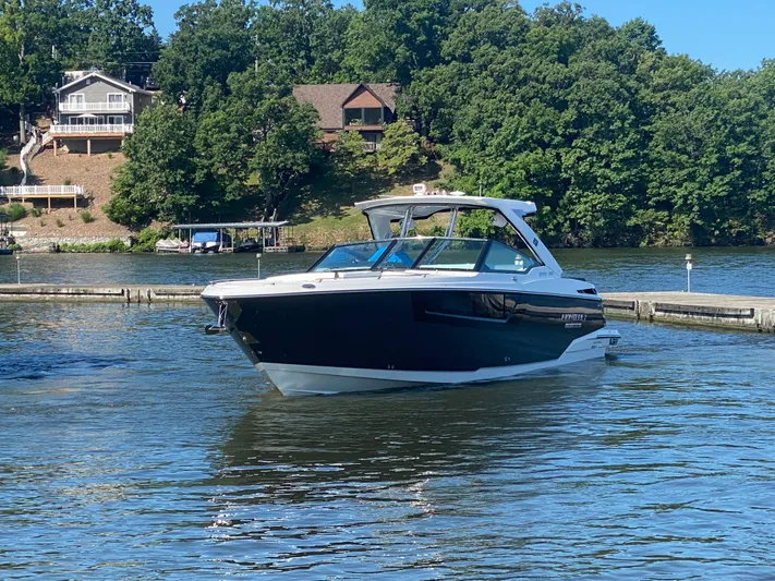 Yacht Photos Pics 2022 Monterey 378SS boat on a serene lake with lush greenery and houses.