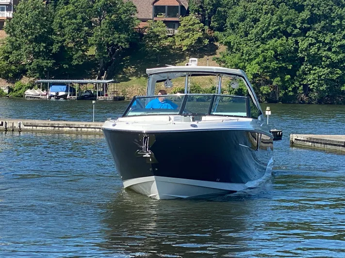  Yacht Photos Pics 2022 Monterey 378SS boat cruising on a serene lake with lush green surroundings.