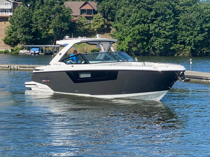  Yacht Photos Pics 2022 Monterey 378SS boat cruising on a scenic lake with lush greenery.