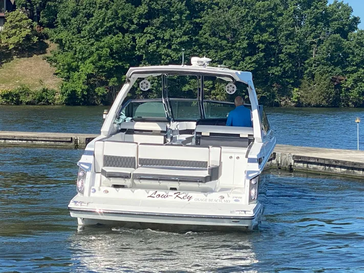  Yacht Photos Pics 2022 Monterey 378SS boat on water near dock, surrounded by lush greenery.