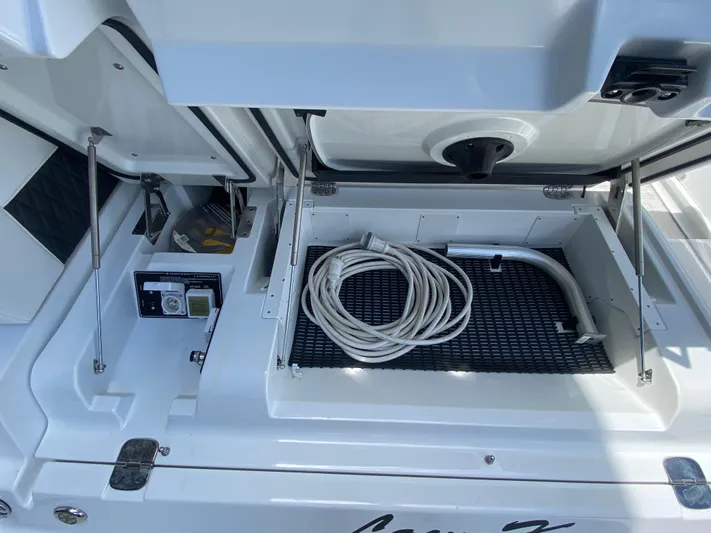  Yacht Photos Pics 2022 Monterey 378SS boat storage compartment with coiled hose and equipment.