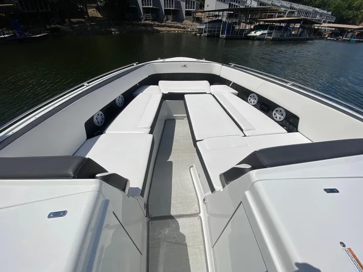  Yacht Photos Pics 2022 Monterey 378SS boat interior with white seating and speakers, docked by the water.
