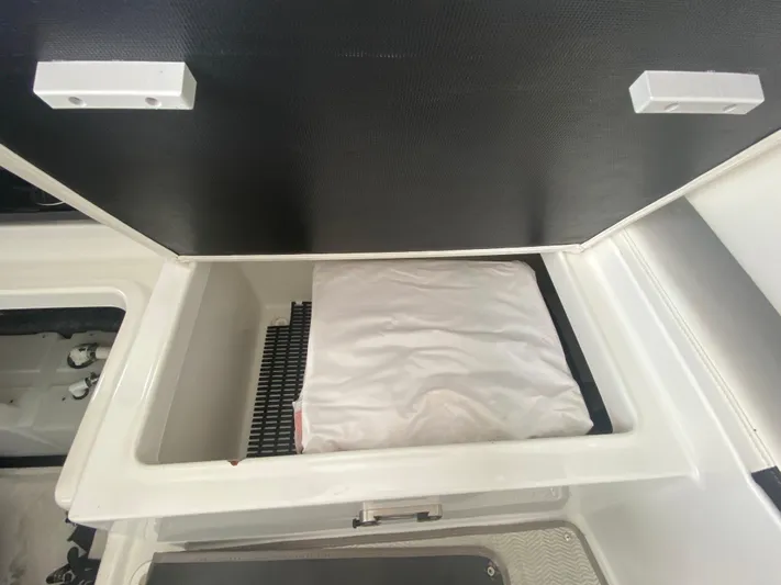  Yacht Photos Pics Open storage compartment in a 2022 Monterey 378SS boat, featuring a white cushion inside.