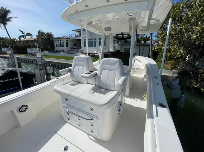  Yacht Photos Pics 2023 Regulator 31 boat with white seating and console, docked near waterfront homes.