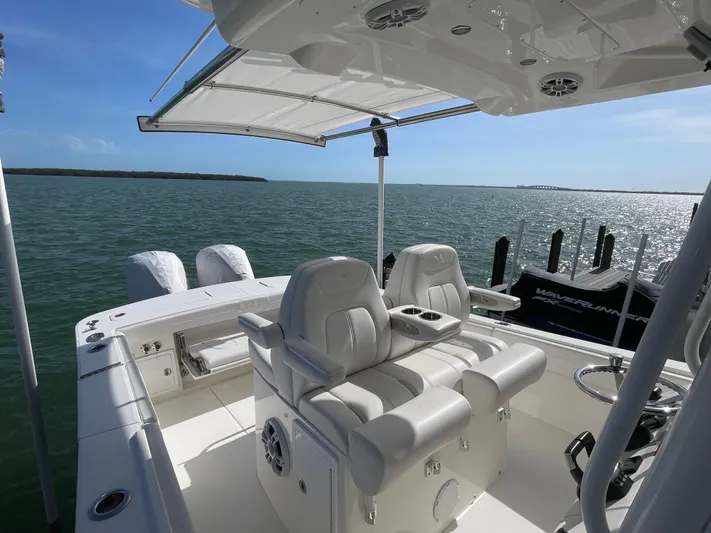  Yacht Photos Pics 2023 Regulator 31 boat interior with dual seats, ocean view, and clear sky.