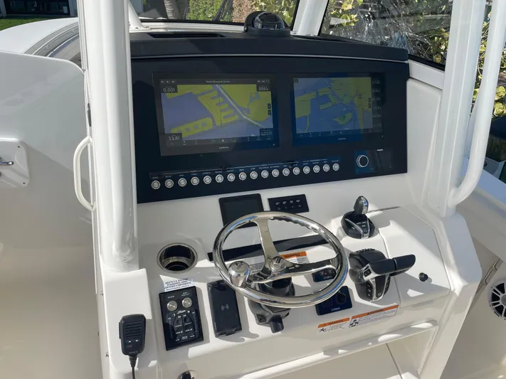  Yacht Photos Pics 2023 Regulator 31 boat dashboard with dual navigation screens and steering wheel.