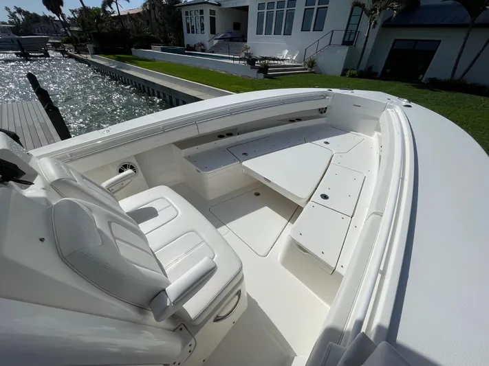  Yacht Photos Pics 2023 Regulator 31 boat interior with white seating and deck, docked by waterfront property.