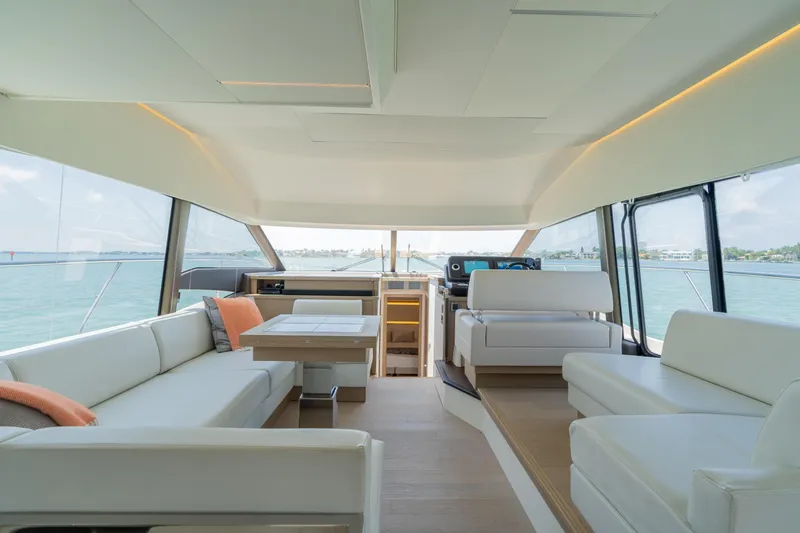 Motivated Seller Yacht Photos Pics Interior of 2019 Prestige 520 Flybridge yacht with modern white seating and panoramic windows.