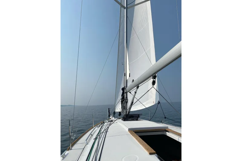  Yacht Photos Pics 2023 Jeanneau Sun Odyssey 349 sailing on calm waters under clear skies.