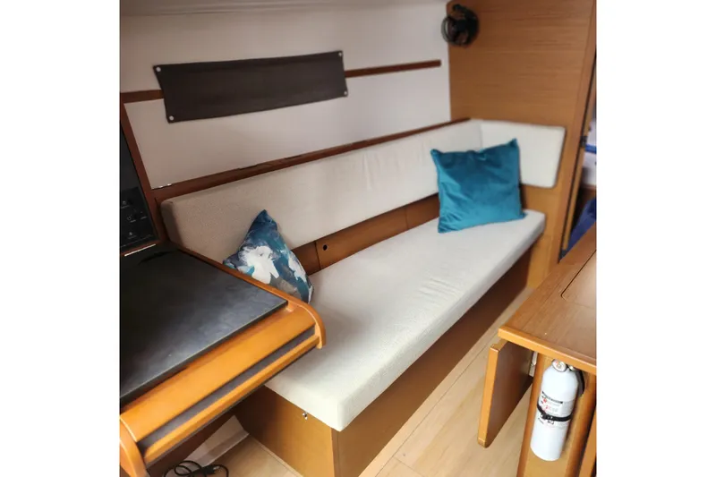  Yacht Photos Pics Interior of 2023 Jeanneau Sun Odyssey 349 with cushioned seating and decorative pillows.