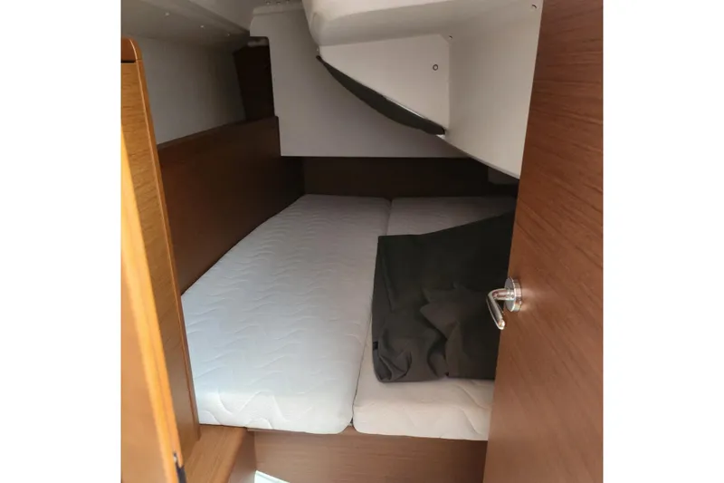  Yacht Photos Pics Cozy cabin interior of 2023 Jeanneau Sun Odyssey 349 sailboat with wooden finish.