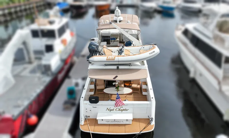 Next Chapter Yacht Photos Pics 2004 Navigator Rival yacht docked, featuring a small boat on deck, American flag displayed.