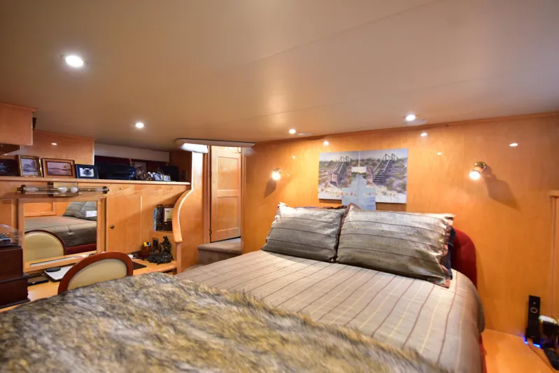 Next Chapter Yacht Photos Pics Luxurious bedroom interior of 2004 Navigator Rival yacht with cozy lighting and elegant decor.