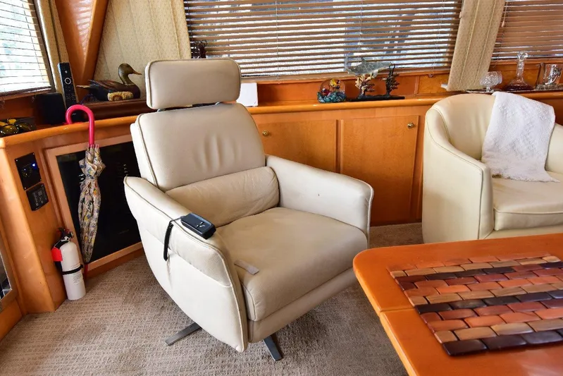 Next Chapter Yacht Photos Pics Luxurious interior of 2004 Navigator Rival yacht with beige leather chair and wooden accents.