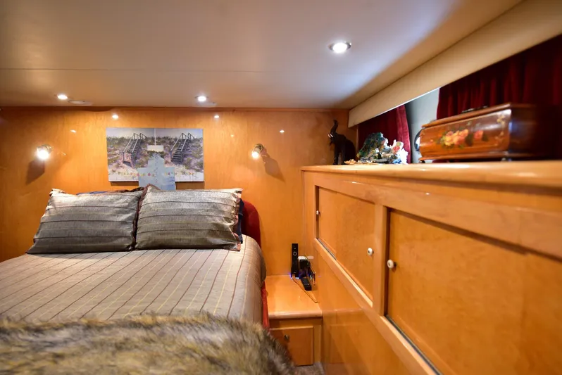 Next Chapter Yacht Photos Pics Luxurious 2004 Navigator Rival yacht bedroom with cozy bedding and elegant wood cabinetry.