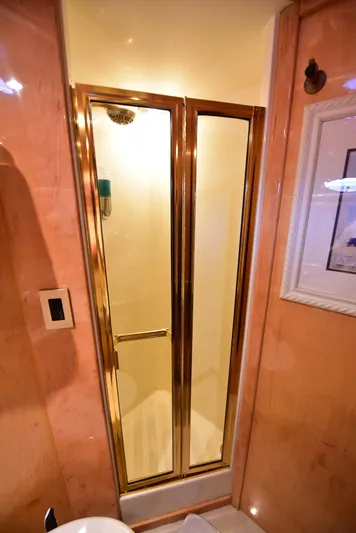 Next Chapter Yacht Photos Pics Luxurious 2004 Navigator Rival shower with gold-framed glass doors in elegant bathroom setting.
