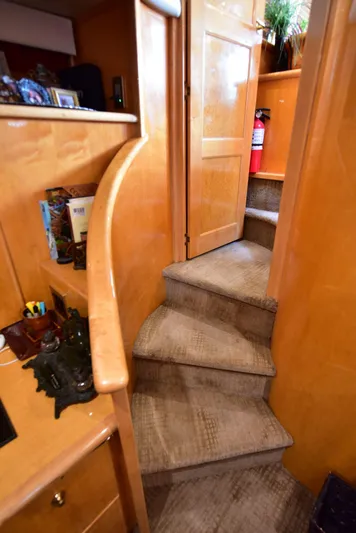 Next Chapter Yacht Photos Pics Interior staircase of 2004 Navigator Rival yacht with wooden finish and carpeted steps.