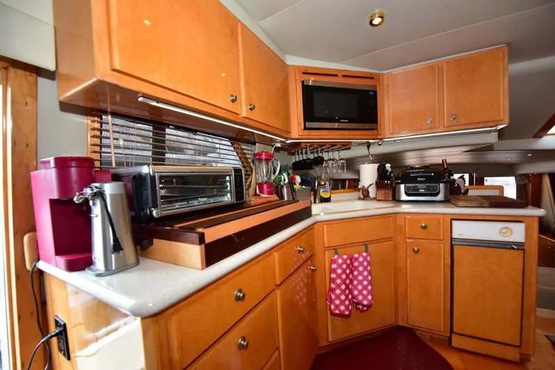Next Chapter Yacht Photos Pics 2004 Navigator Rival kitchen with wooden cabinets, appliances, and cozy decor.