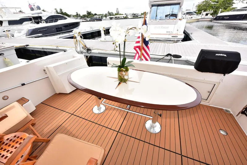 Next Chapter Yacht Photos Pics Luxurious 2004 Navigator Rival yacht deck with elegant table and chairs.
